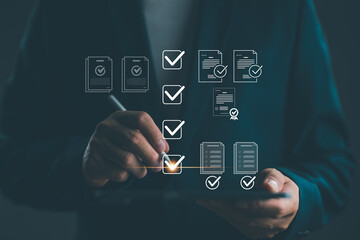 Businessman using digital tablet with virtual checklist icons and verified documents, representing...