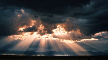 A dramatic sky filled with dark clouds and rays of sunlight breaking through, illuminating the landscape below.