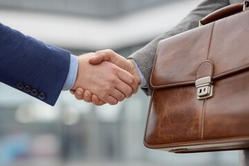 A manager shaking hands with a new contact, a briefcase rests nearby, the mood feels formal yet friendly, Generative AI 