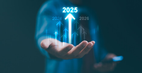 Hand holding up glowing 2025 with upward arrows, symbolizing business growth, future success, and...