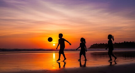 Fototapeta premium Silhouettes of children playing soccer on a beach at sunset, showcasing a vibrant orange and purple sky.