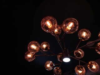 Aesthetic chandelier with a series of yellow lights and circular glass covering it