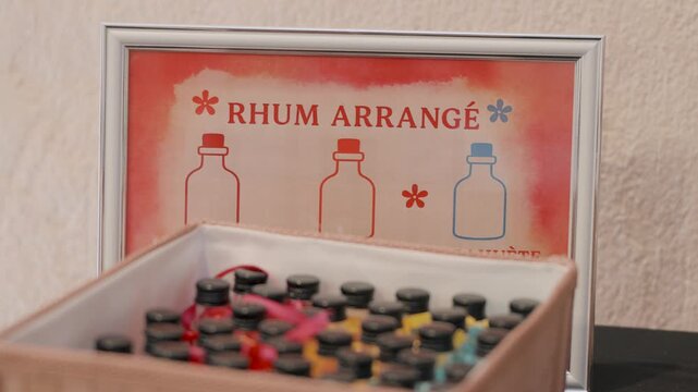 Wedding detail with artisanal "rhum arrang&eacute;" bottles in a decorative box. Perfect shot for festive celebrations, receptions, or unique gift ideas.