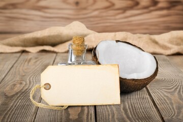Liquid fresh coconut oil and coco-nut fruit on table.
