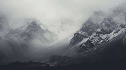 Misty snow covered mountain peaks under a cloudy sky mountains clouds