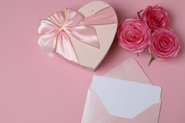 Pink rose with gift on pink background
