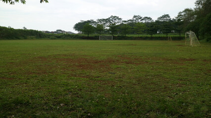 Empty Soccer Field with Goalposts and Trees © Adipra