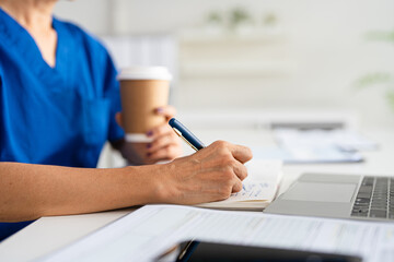 closeup Hand Writing, book and notebook by doctor or healthcare professional with a prescription or making notes in an office.