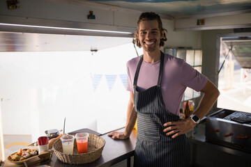 Woven basket is holding lemonade and red juice cups with takeout tray on food truck counter