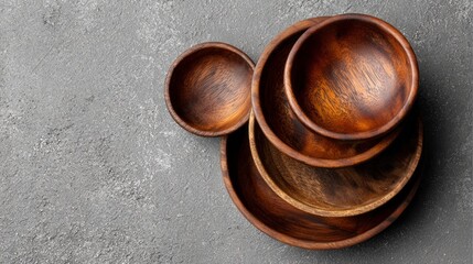 A stack of wooden bowls on a grey countertop