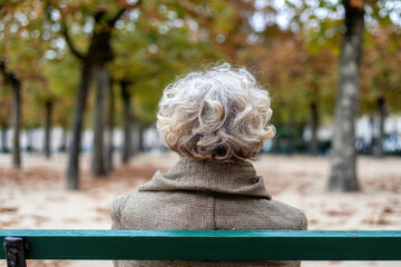 Rear view of senior woman sitting on park bench