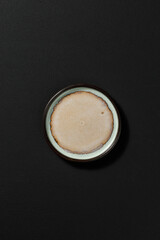 Minimalist ceramic plate, placed on a dark textured background