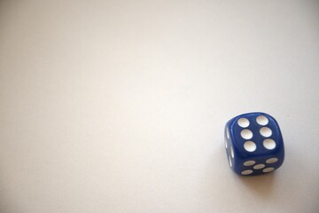 One blue dice showing six dots isolated on a white background, close-up with copy space.