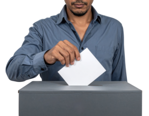 A man in a blue shirt casts his vote by placing a ballot into a voting box.