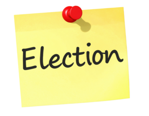 A yellow sticky note with the word "Election" written in bold, black letters, pinned with a red thumbtack.