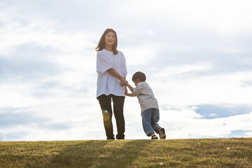 夕方の公園で手を繋ぐ親子