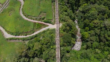 Aerial view of abandoned railway bridge crossing jungle valley