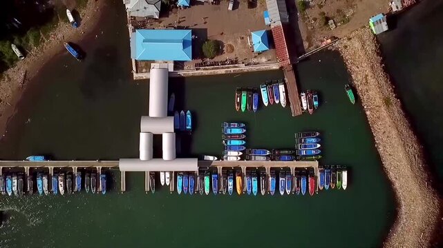 Aerial view of Sofifi harbor with speed boats docked and departing, showing sea transportation hub in North Maluku, Indonesia.