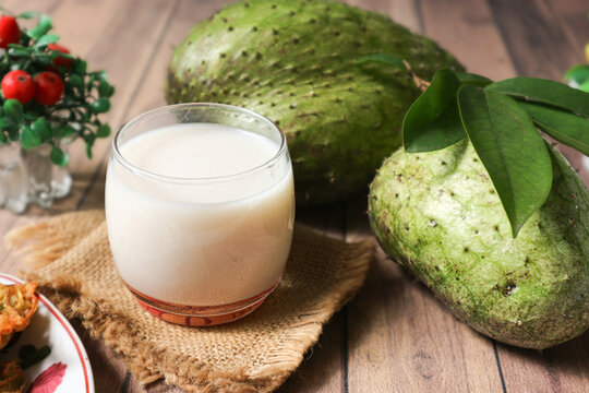 A glass of jus sirsak, Indonesia&rsquo;s tropical soursop juice, sits beside two ripe fruits. Naturally sweet and packed with vitamin C, it&rsquo;s a refreshing boost in every sip.