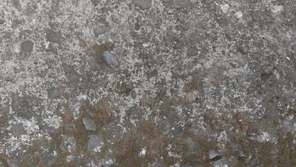 Close-up of a rough, weathered concrete surface with small stones and natural erosion. This raw texture is ideal for use in 3D modeling, digital artwork, architecture references, or urban backgrounds.