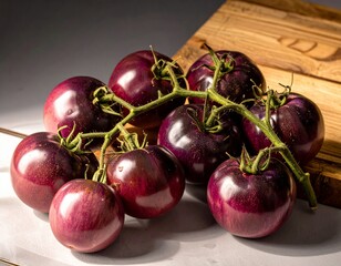 A striking bunch of fresh, vine-ripened dark purple heirloom tomatoes presented on a wooden surface, highlighting their unique color and readiness for healthy gourmet cooking