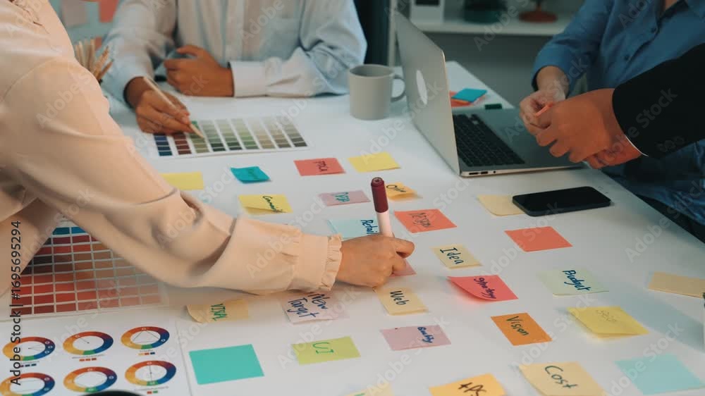 Aufkleber a diverse team collaborates in a bright office setting, using colorful sticky notes and digital devi