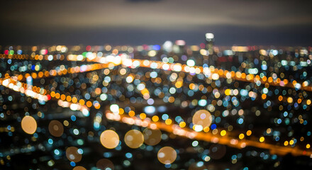 Abstract aerial view of a city at night, with blurred lights creating a bokeh effect.