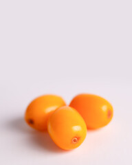 Sea buckthorn berries arranged on light background, natural skincare concept, copy space.