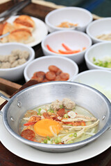 Breakfast with fried eggs in a pan with bacon and vegetables on dark background, top view