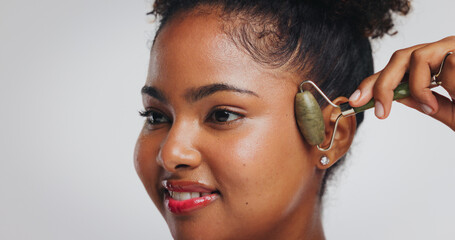 Beauty, jade roller and woman with smile in studio for skin benefits, lymphatic drainage or glow....