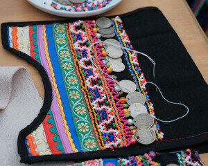 Traditional Mari women s chest ornament in progress with beads, coins, and ribbon