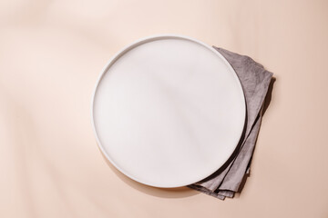 Empty plate on beige background, food mockup with natural light