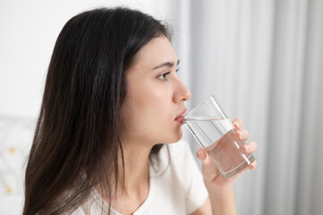 Young woman drinking water in the morning to maintain health
