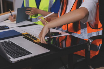 Closeup of team of industrial engineers meeting analyze machinery blueprints consult project on...