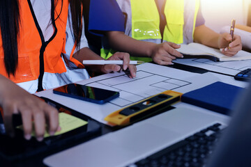Closeup of team of industrial engineers meeting analyze machinery blueprints consult project on...
