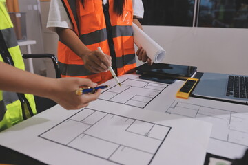 Closeup of team of industrial engineers meeting analyze machinery blueprints consult project on...