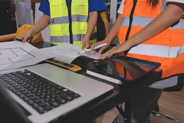 Closeup of team of industrial engineers meeting analyze machinery blueprints consult project on...
