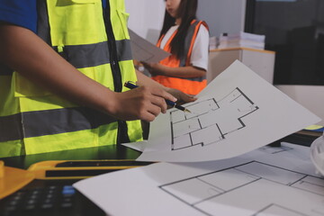 Closeup of team of industrial engineers meeting analyze machinery blueprints consult project on...