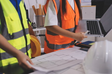 Closeup of team of industrial engineers meeting analyze machinery blueprints consult project on table in manufacturing factory. Working in manufacturing plant or production plant.