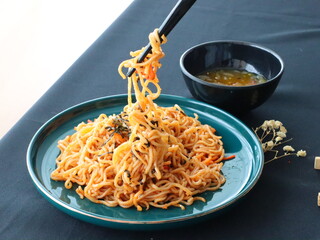 Stir-fried instant noodles with vegetables and meat, a quick and flavorful Thai comfort food dish loved for its savory taste.
