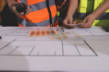 Closeup of team of industrial engineers meeting analyze machinery blueprints consult project on...