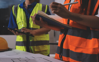 Closeup of team of industrial engineers meeting analyze machinery blueprints consult project on...