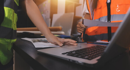Closeup of team of industrial engineers meeting analyze machinery blueprints consult project on...