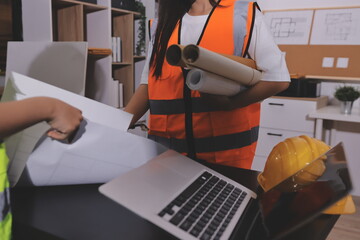 Closeup of team of industrial engineers meeting analyze machinery blueprints consult project on...