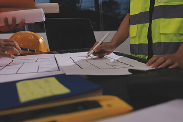 Closeup of team of industrial engineers meeting analyze machinery blueprints consult project on...