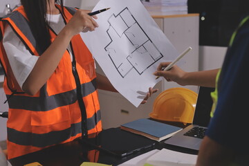 Closeup of team of industrial engineers meeting analyze machinery blueprints consult project on...