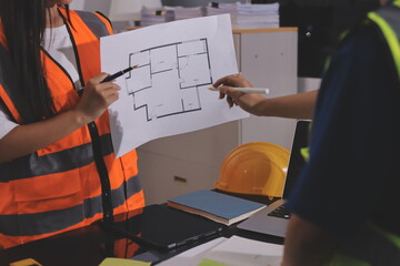 Closeup of team of industrial engineers meeting analyze machinery blueprints consult project on...