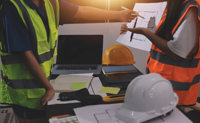 Closeup of team of industrial engineers meeting analyze machinery blueprints consult project on...