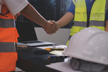 Closeup of team of industrial engineers meeting analyze machinery blueprints consult project on...