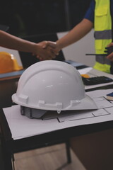Closeup of team of industrial engineers meeting analyze machinery blueprints consult project on...